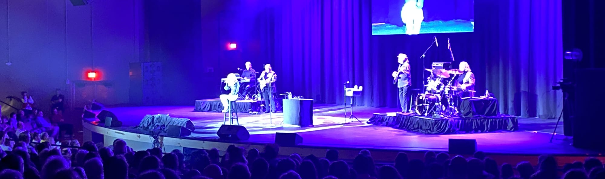signer on stage in chair washed out by the lights St Louis